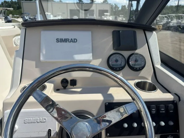 Slide: The Image of The image shows the helm of a Boston Whaler 210 Vantage with a Simrad display and gauges. - 15