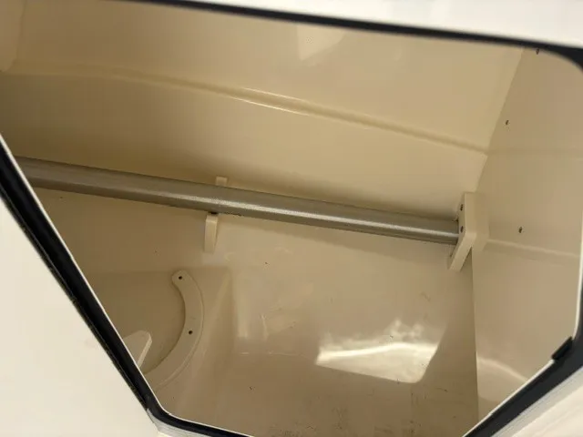 Slide: The Image of An empty storage compartment inside a boat with a metal rod. - 13