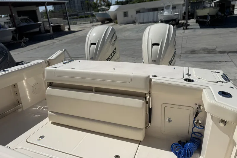Slide: The Image of 2026 Grady-White Canyon 336 boat interior with dual outboard motors in a marina setting. - 32