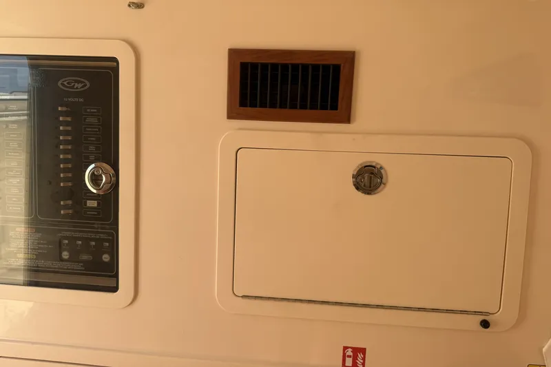 Slide: The Image of Control panel and storage compartment on 2026 Grady-White Canyon 336 boat interior. - 27