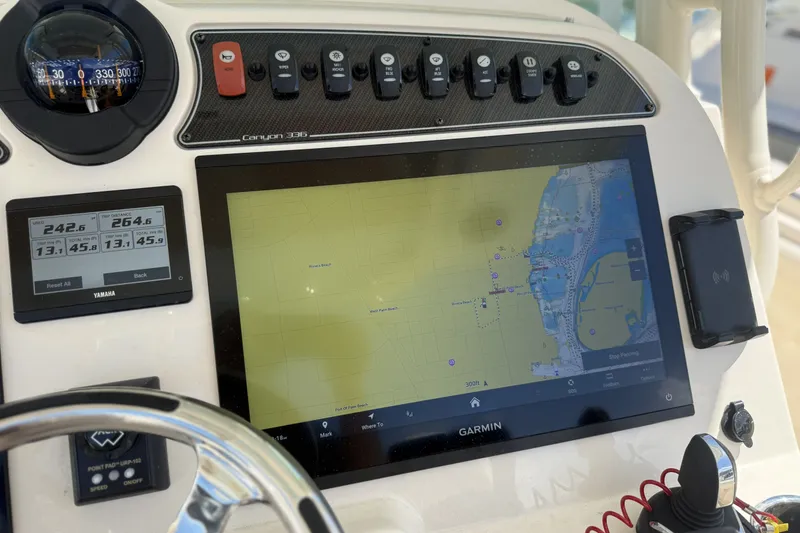 Slide: The Image of 2026 Grady-White Canyon 336 dashboard with Garmin navigation and Yamaha display. - 13