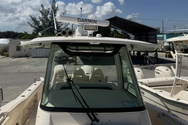Slide: The Image of 2026 Grady-White Canyon 336 boat with Garmin radar, docked under clear skies. - 23