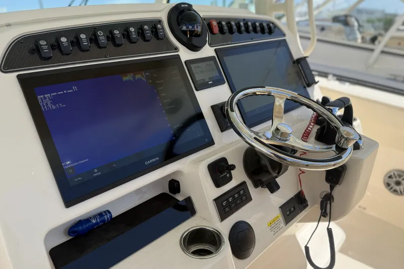 Slide: The Image of 2026 Grady-White Canyon 336 boat dashboard with steering wheel and navigation screens. - 14