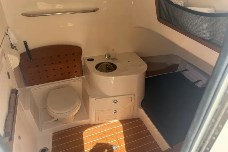 Slide: The Image of 2026 Grady-White Canyon 336 boat interior with toilet, sink, and storage. - 29