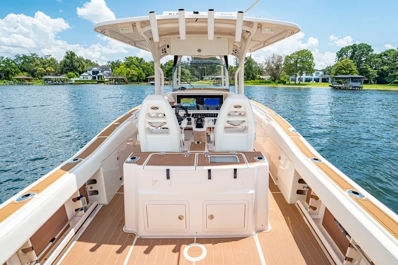 Slide: The Image of 2015 Grady-White Canyon 306 boat interior on a serene lake with lush greenery. - 31