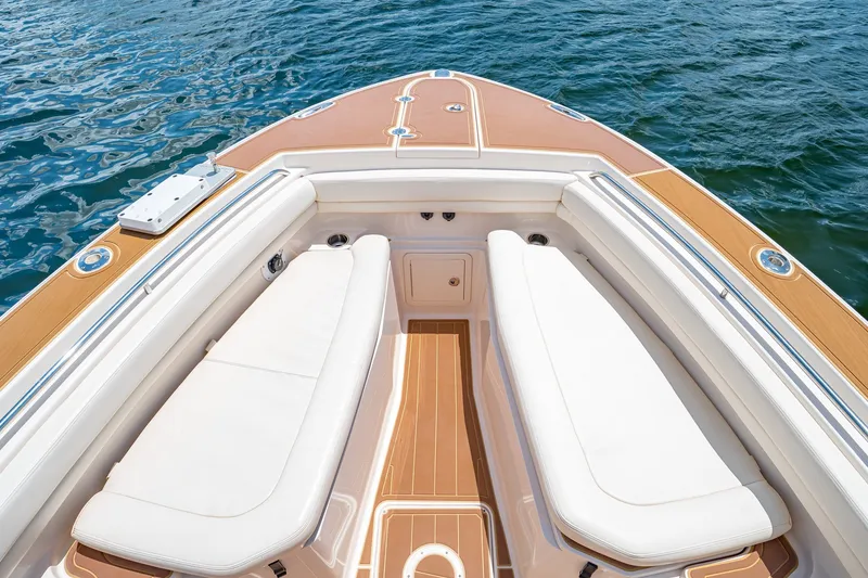Slide: The Image of 2015 Grady-White Canyon 306 boat interior with white seating and teak flooring on water. - 45