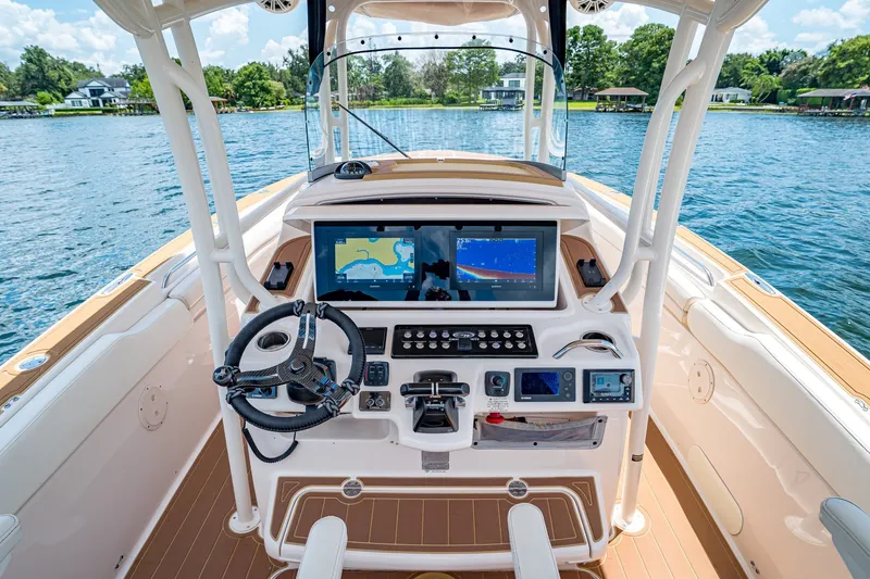 Slide: The Image of 2015 Grady-White Canyon 306 boat helm with advanced navigation system on a serene lake. - 39