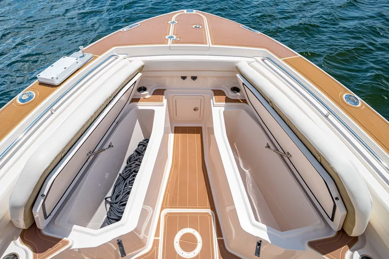 Slide: The Image of 2015 Grady-White Canyon 306 boat deck with open storage compartments, on calm water. - 47