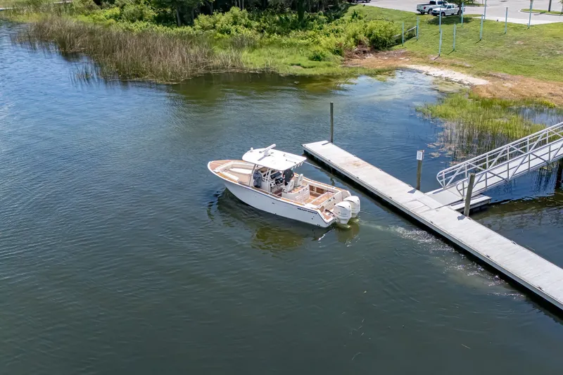 Slide: The Image of 2015 Grady-White Canyon 306 boat docking at a serene lakeside pier. - 20