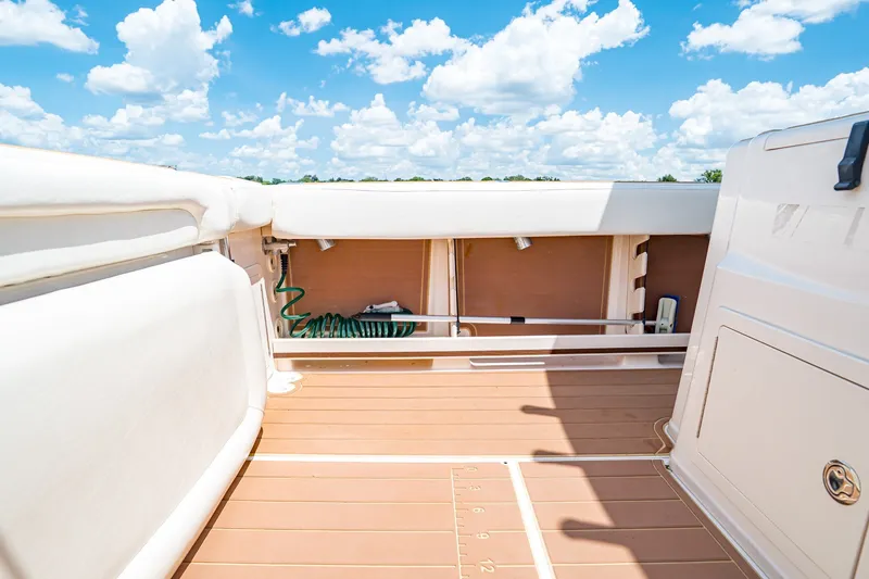 Slide: The Image of 2015 Grady-White Canyon 306 boat deck under a bright blue sky with clouds. - 24