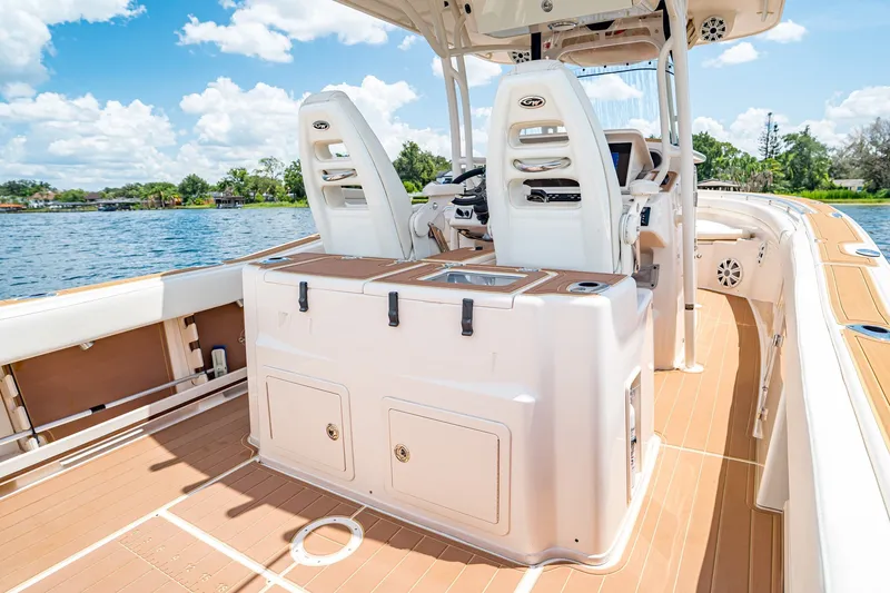 Slide: The Image of 2015 Grady-White Canyon 306 boat interior with helm seats and storage, on a sunny day. - 25