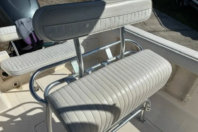 Slide: The Image of 2005 Key West 225 Center Console boat seating with white cushioned bench and chrome details. - 12