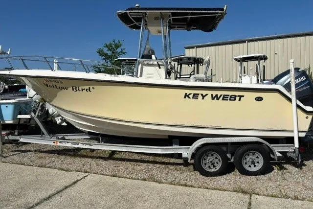 The Image of 2005 Key West 225 Center Console boat on trailer, labeled "Yellow Bird," parked outdoors. - 1