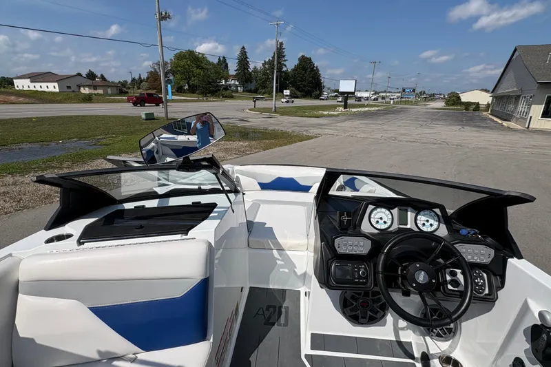 Slide: The Image of 2021 Axis A20 boat interior with steering wheel and dashboard, parked on a sunny day. - 14