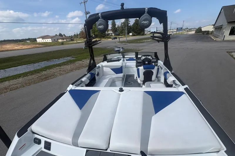 Slide: The Image of 2021 Axis A20 boat with blue and white interior, parked on a paved area. - 5