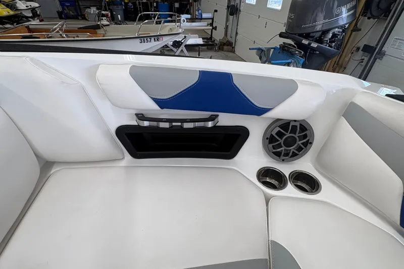 Slide: The Image of Interior of 2021 Axis A20 boat featuring speaker, cup holders, and cushioned seating. - 28
