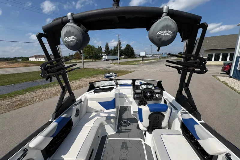 Slide: The Image of 2021 Axis A20 boat interior with speakers and seating, parked outdoors under a clear sky. - 8