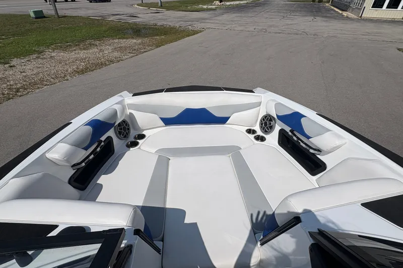 Slide: The Image of 2021 Axis A20 boat interior with white and blue seating, cup holders, and speakers. - 16