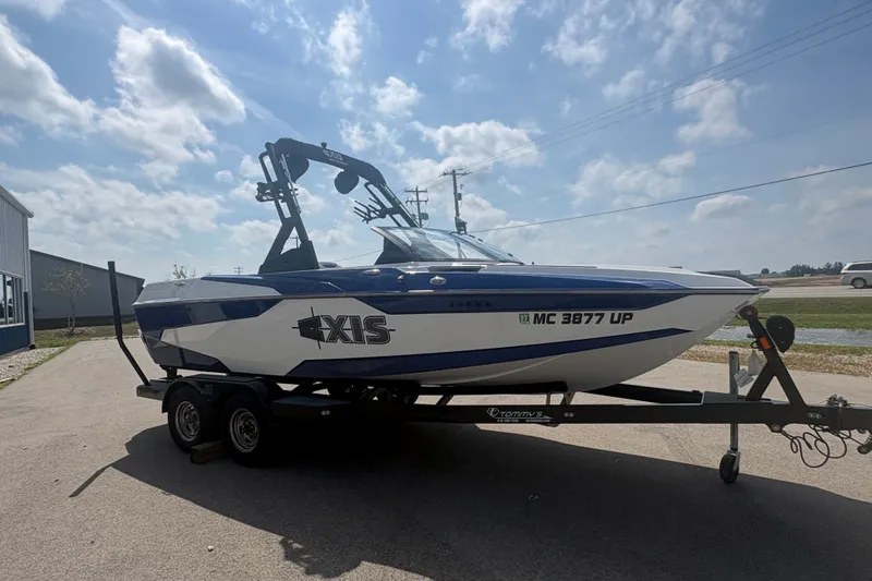 Slide: The Image of 2021 Axis A20 boat on trailer under a partly cloudy sky. - 1