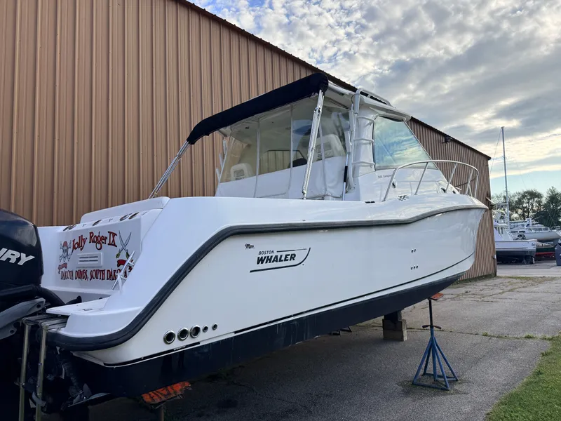 Slide: The Image of A 2013 Boston Whaler 345 Conquest on a trailer beside a building. - 1
