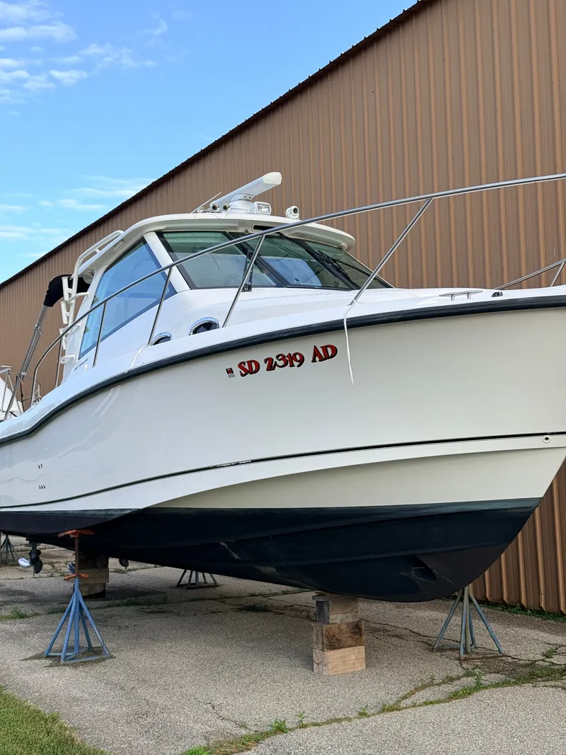 Slide: The Image of A 2013 Boston Whaler 345 Conquest is propped up on stands beside a building. - 3