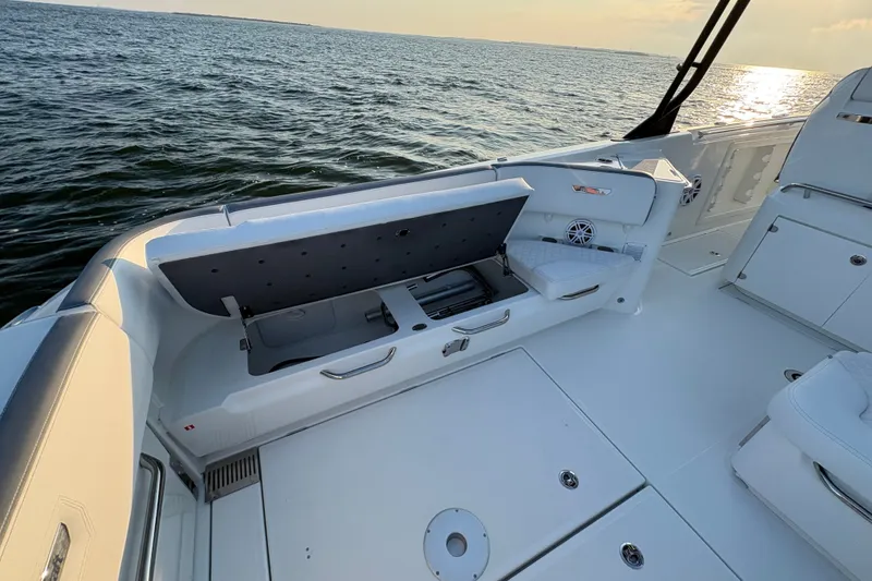 Slide: The Image of 2026 Wellcraft 38 T-Top boat interior with open storage compartment, on calm water. - 16