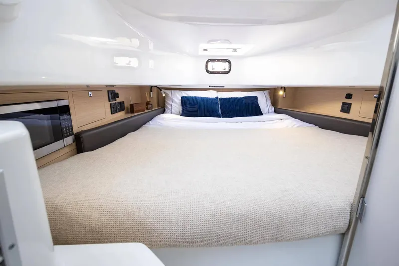 Slide: The Image of Cozy cabin interior of 2026 Wellcraft 38 T-Top with bed and microwave. - 22