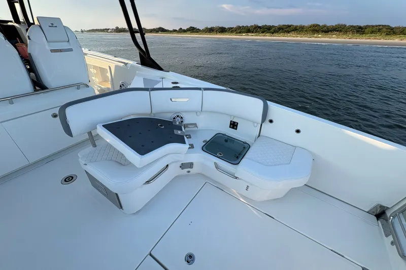 Slide: The Image of 2026 Wellcraft 38 T-Top boat interior with seating, ocean view, and shoreline in background. - 15