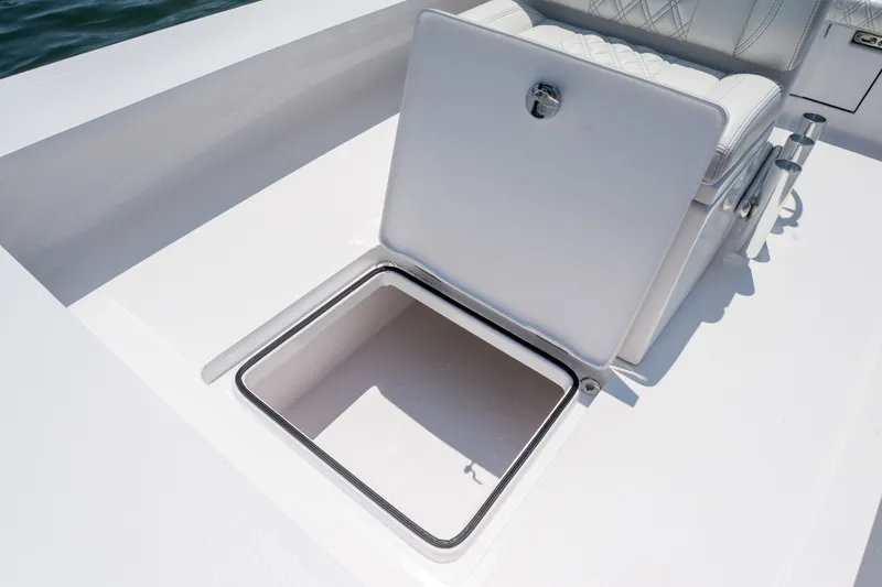 Slide: The Image of Open storage compartment on a 2021 Vtech 18 FLATS boat, featuring white cushioned seating. - 17