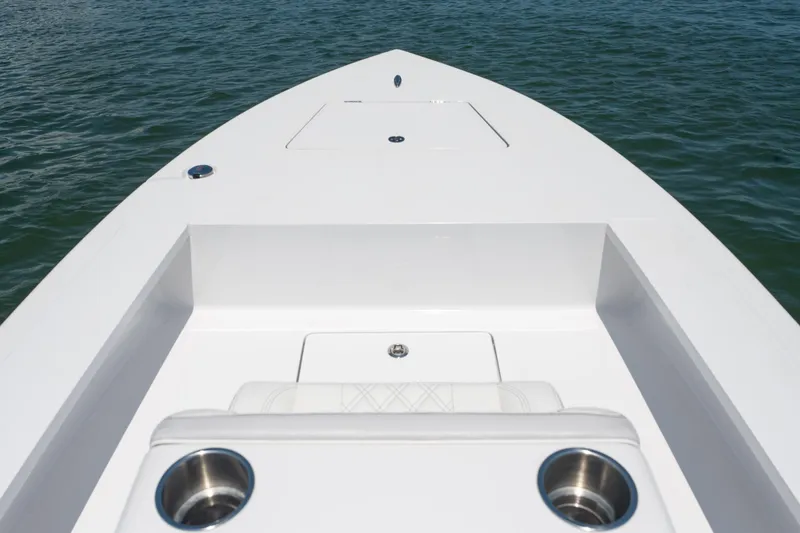 Slide: The Image of Bow view of 2021 Vtech 18 FLATS boat on water, featuring sleek white design. - 16