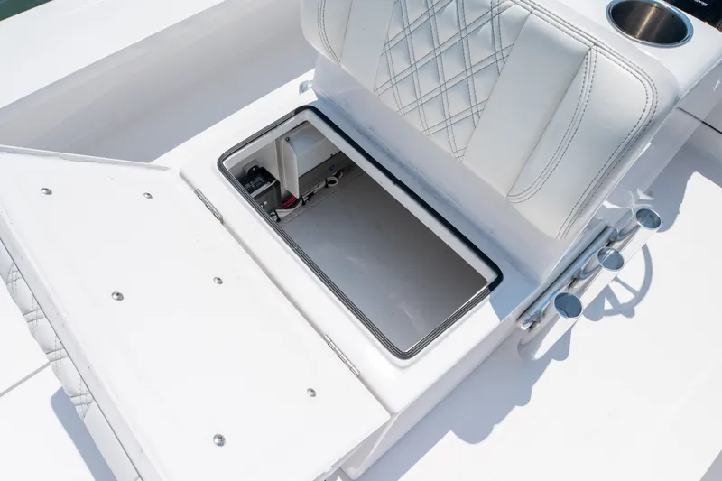 Slide: The Image of Open storage compartment on a 2021 Vtech 18 FLATS boat with white cushioned seating. - 18