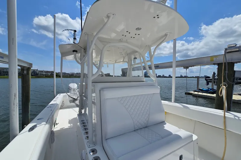 Slide: The Image of 2006 SeaVee 340B boat interior with white seating, docked by the water under a blue sky. - 19