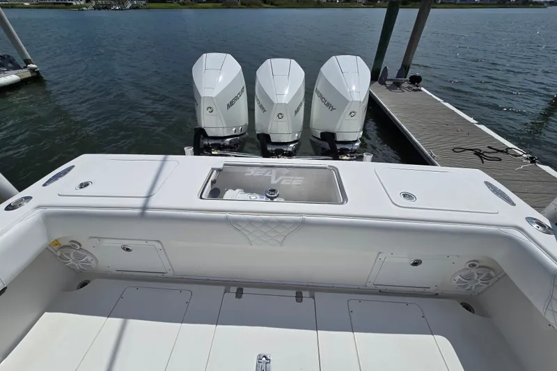Slide: The Image of 2006 SeaVee 340B boat with triple Mercury engines docked by the water. - 23