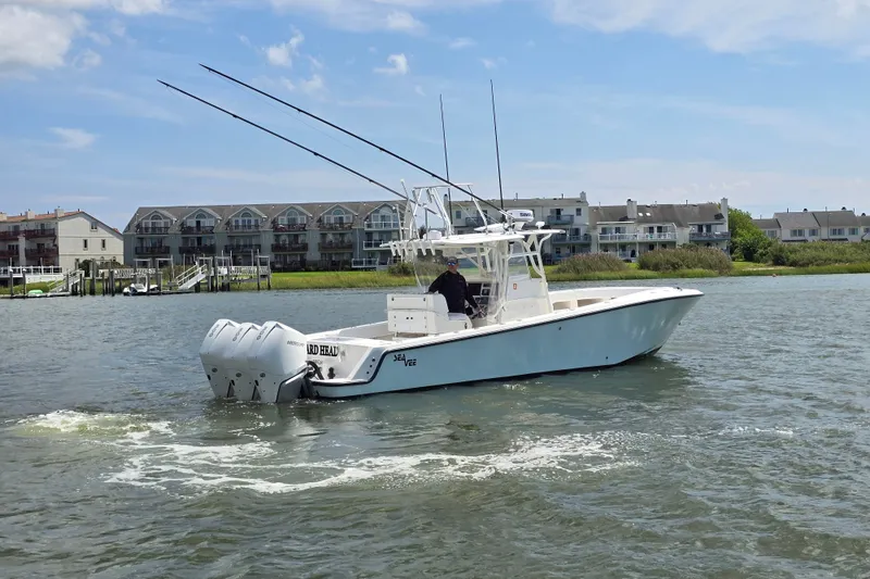 Slide: The Image of 2006 SeaVee 340B boat cruising on water near residential buildings. - 13