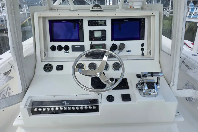 Slide: The Image of 2006 SeaVee 340B boat dashboard with steering wheel, dual screens, and control panel. - 14