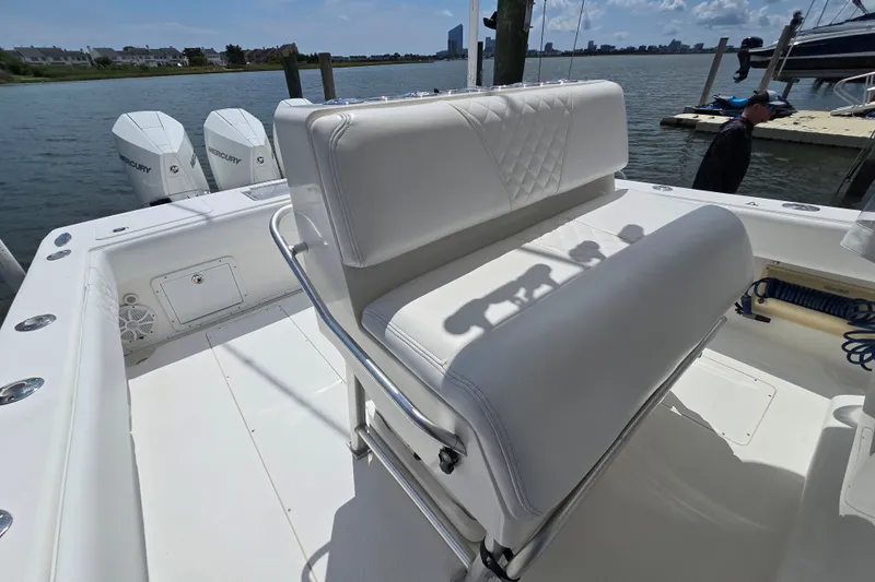 Slide: The Image of 2006 SeaVee 340B boat with white seating and Mercury engines docked by the water. - 25