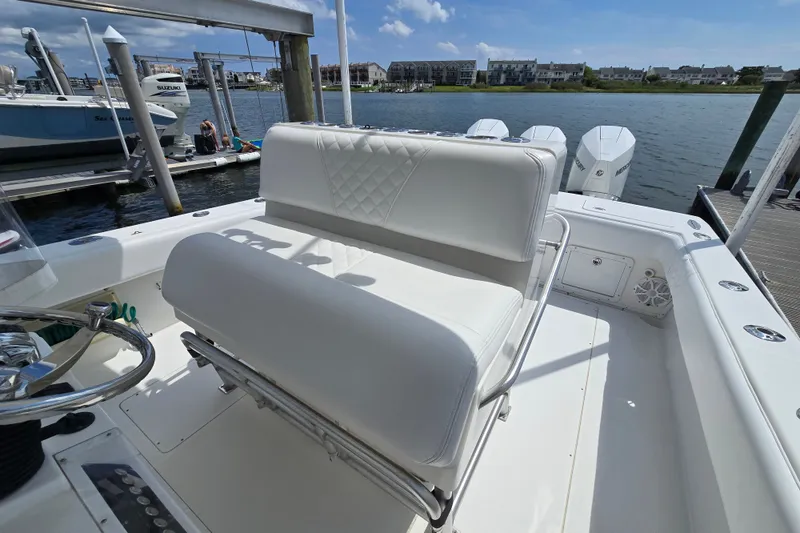 Slide: The Image of 2006 SeaVee 340B boat interior with white seating and steering wheel, docked by the water. - 21