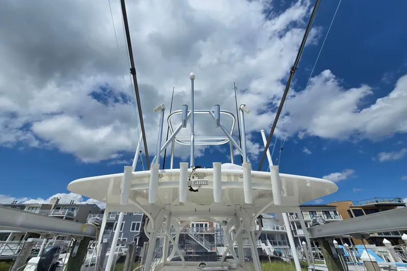 Slide: The Image of 2006 SeaVee 340B boat with fishing rods, under a bright blue sky with clouds. - 26
