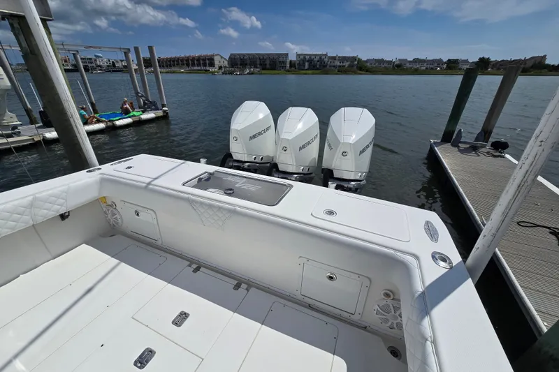 Slide: The Image of 2006 SeaVee 340B boat with triple Mercury engines docked by the water. - 22