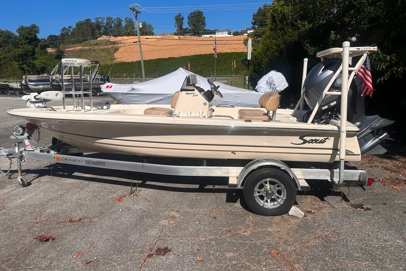 Slide: The Image of 2022 Ocean Scout Sport 177 boat on trailer, parked outdoors with American flag. - 17