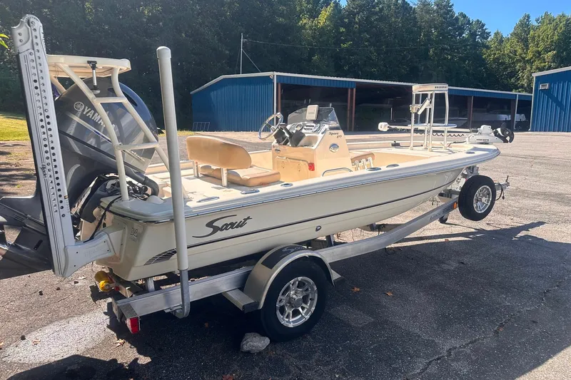 Slide: The Image of 2022 Ocean Scout Sport 177 boat on trailer, parked outdoors near blue storage buildings. - 19