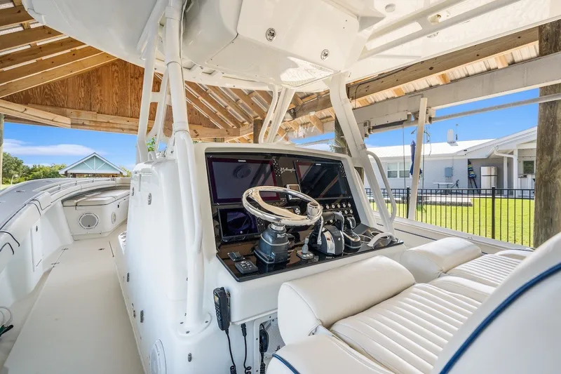 Slide: The Image of 2013 Yellowfin 39 Offshore boat cockpit with modern controls and seating under a wooden canopy. - 70