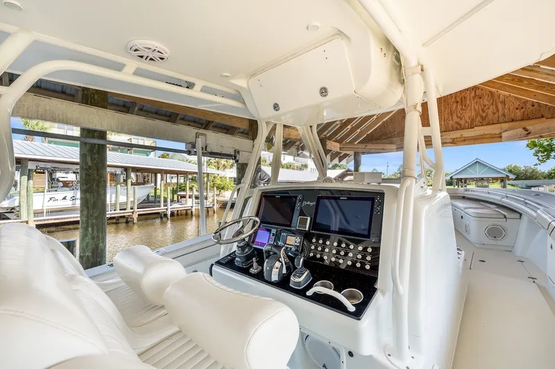 Slide: The Image of 2013 Yellowfin 39 Offshore boat interior with modern navigation equipment and white seating. - 71