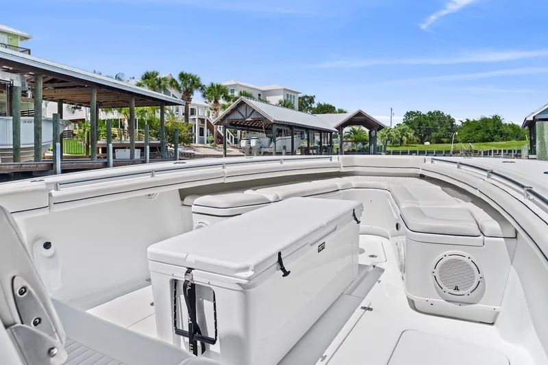 Slide: The Image of 2013 Yellowfin 39 Offshore boat interior with seating and storage, docked near waterfront homes. - 35