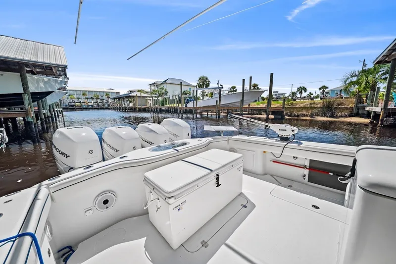 Slide: The Image of 2013 Yellowfin 39 Offshore boat with multiple Mercury engines docked by waterfront homes. - 18