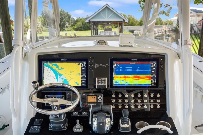 Slide: The Image of 2013 Yellowfin 39 Offshore boat dashboard with navigation screens and controls. - 60