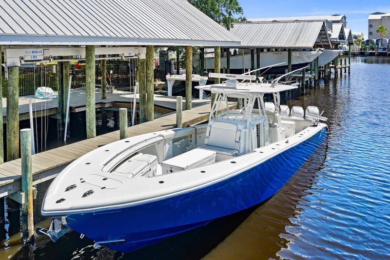 Slide: The Image of 2013 Yellowfin 39 Offshore boat docked, featuring sleek blue hull and spacious deck. - 11