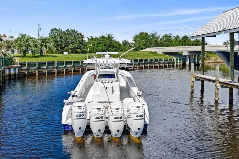 Slide: The Image of 2013 Yellowfin 39 Offshore boat with four powerful outboard engines docked in a canal. - 9