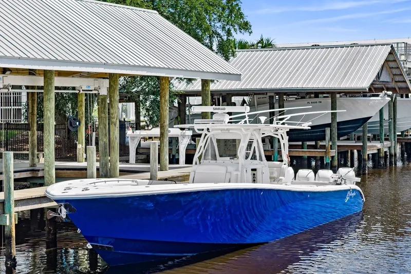 Slide: The Image of 2013 Yellowfin 39 Offshore boat docked, featuring a sleek blue hull and modern design. - 15