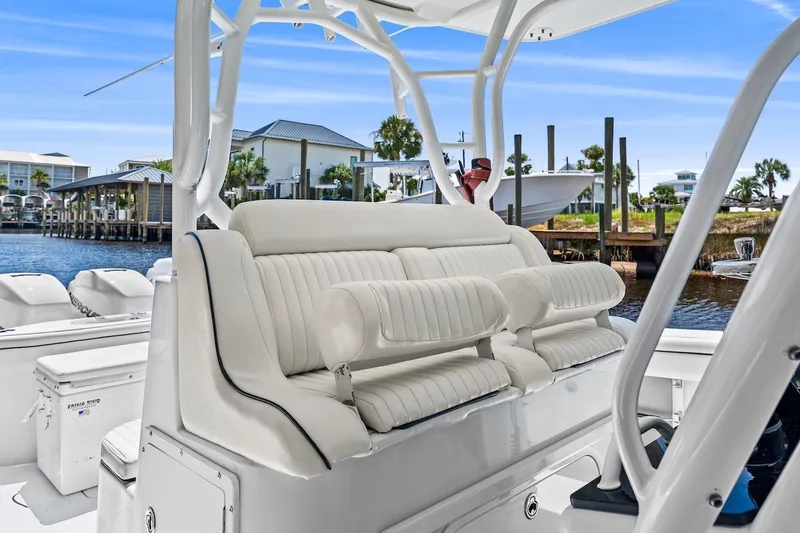 Slide: The Image of 2013 Yellowfin 39 Offshore boat interior with white seating and waterfront view. - 32